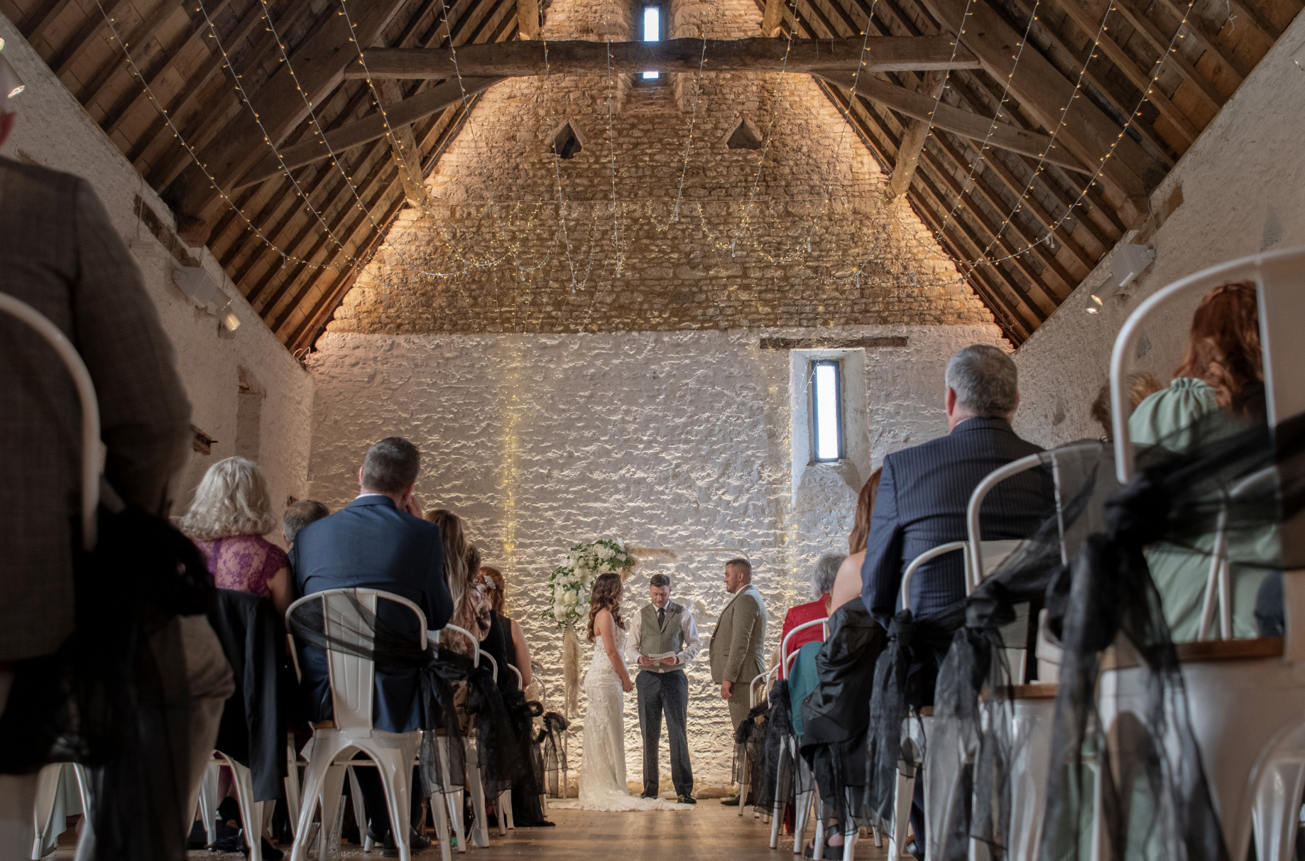 An intimate ceremony in the historic stone barn at Chester House Estate.